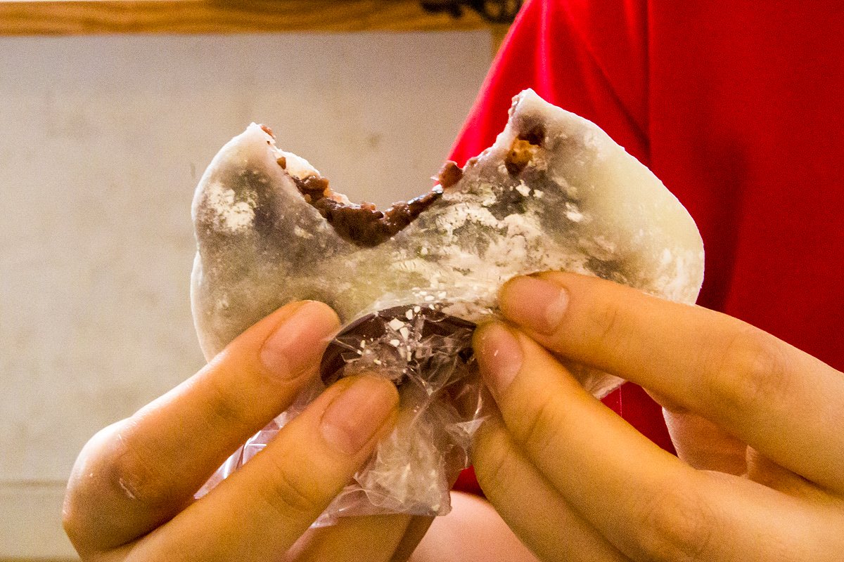 Hands pulling apart a Korean chapssal-tteok rice cake to eat