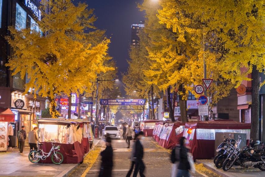 Evening street scene in Jongno 3-ga with food tents and autumn ginkgo trees