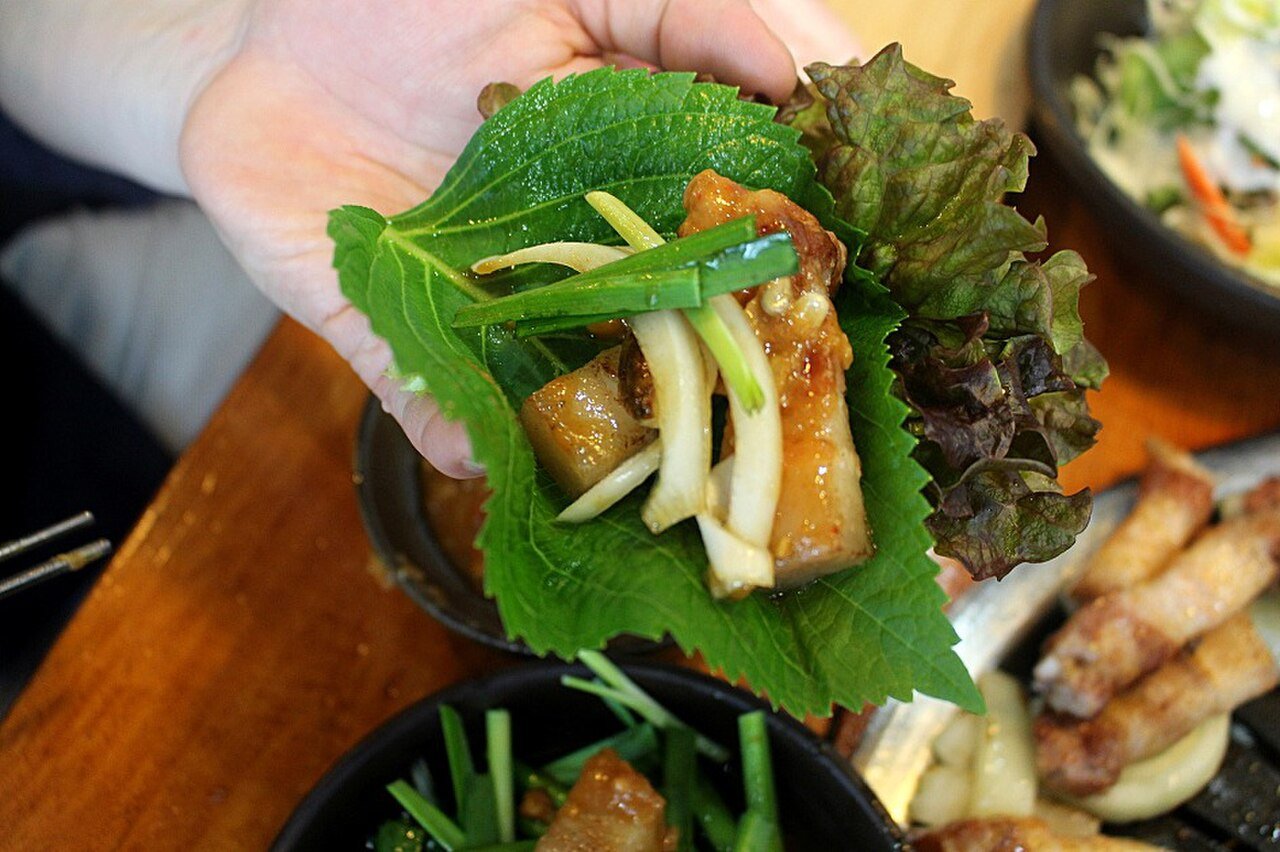 Samgyeopsal ssam: grilled pork belly wrapped in perilla and lettuce leaves with green onion