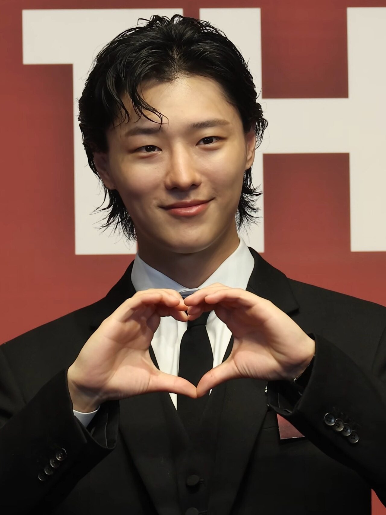 WOODZ making a heart gesture at the 2026 Brand of the Year Awards
