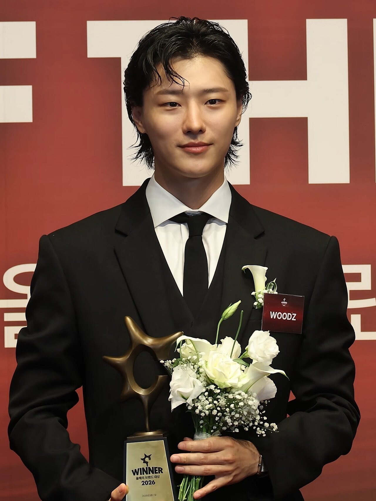 WOODZ holding his trophy at the 2026 Brand of the Year Awards