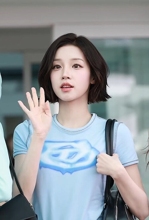 i-dle YUQI waving at an airport departure in July 2026